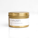 A white cylindrical candle with a wooden lid, labeled 'LUMINOUS' and 'ORGANIC'.