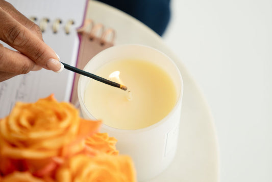 Pivotal Moments Candle being lit with an elegant gold tipped match.
