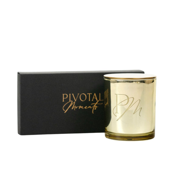 Gold candle with candle care accessory kit in a black box.
