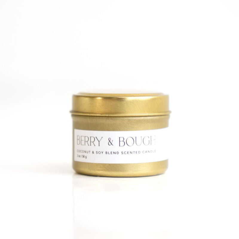 A cold tin candle with a gold-colored lid featuring a Christmas-themed scent. The lid has the initial 'DP' in gold letters.