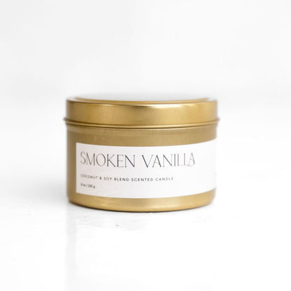 A white cylindrical candle with a wooden lid labeled 'SMOKEN VANILLA'.