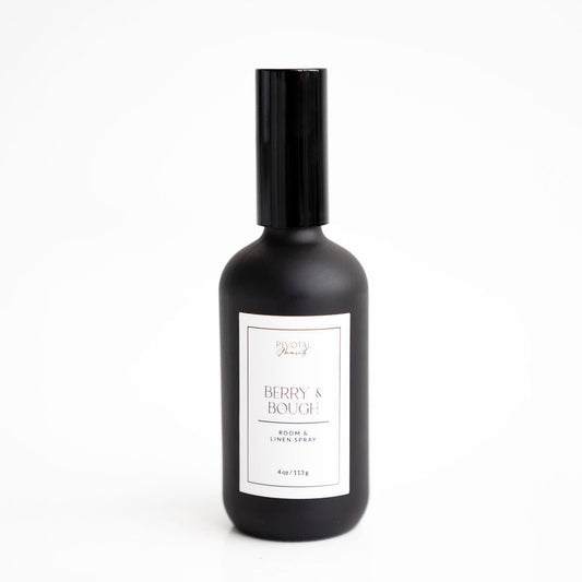 A black bottle of 'Berry & Bough' room and linen spray by ALOFT with a white label.