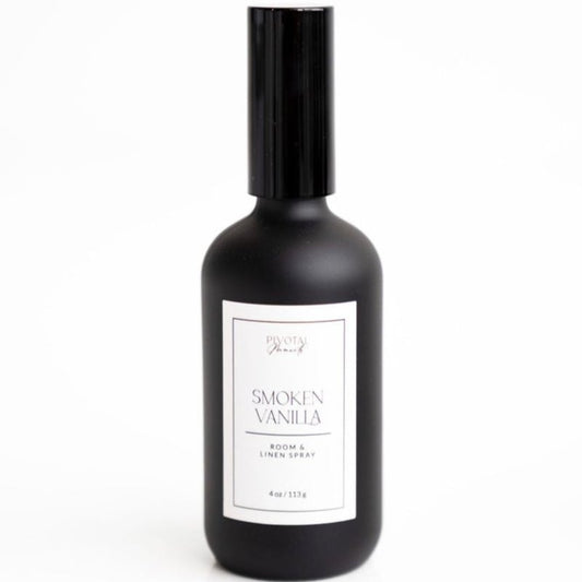 A black bottle of 'Smoked Vanilla' room and linen spray with a white label, containing 4 oz (120 ml).