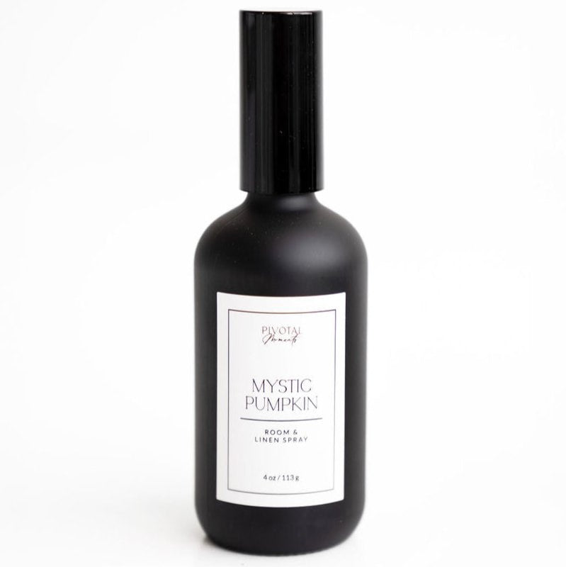 A black bottle labeled 'Mystic Pumpkin' room and linen spray by Daisies & Co. with a white label and cap.