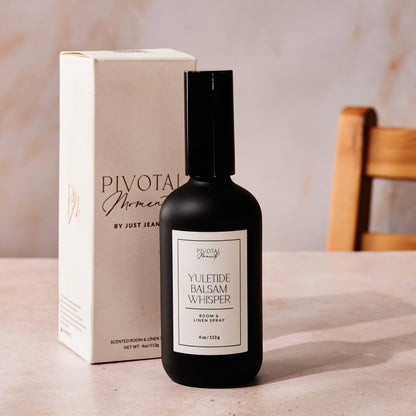 Black bottle with white label and beige box labeled 'Pivotal Moments' on a light surface.