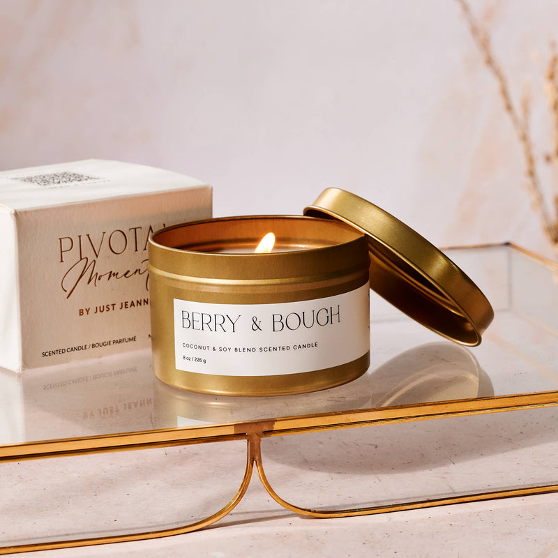 Gold candle jar with 'Berry & Bough' label on a reflective surface