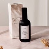 Black bottle with white label on a beige surface next to a white box with 'Pivot' branding.