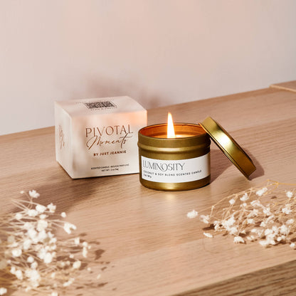 Candle with a box labeled 'Pivotal Elements' on a wooden surface with decorative elements.
