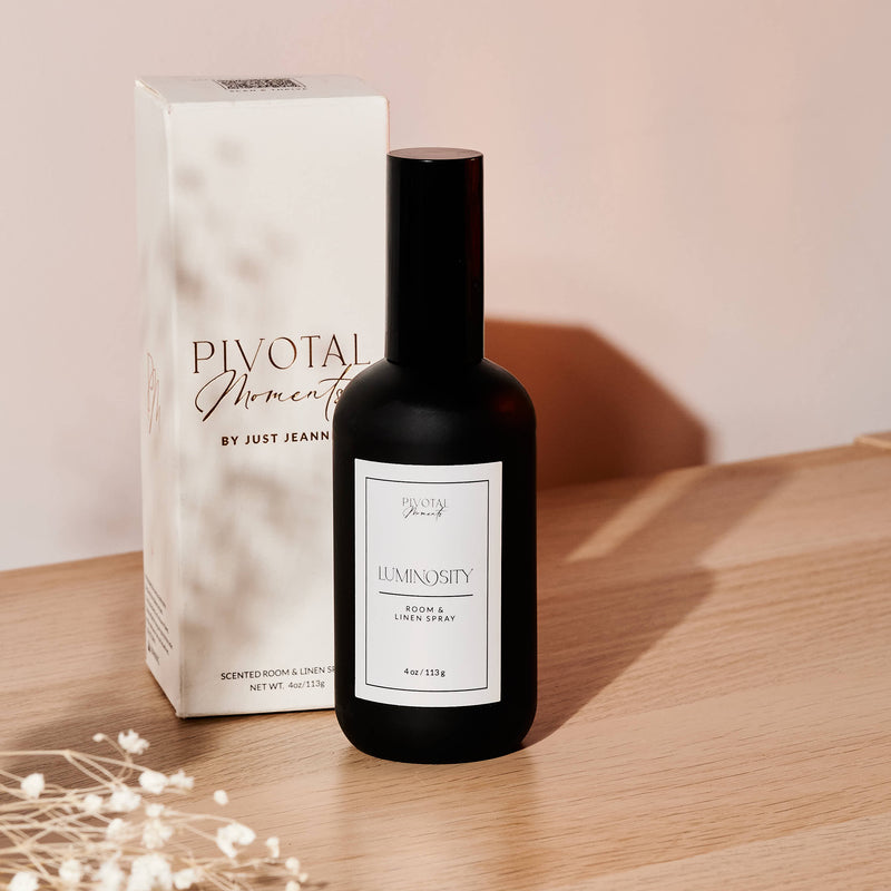 Black bottle with white label on a wooden surface next to a box labeled 'Pivotal Moments'.