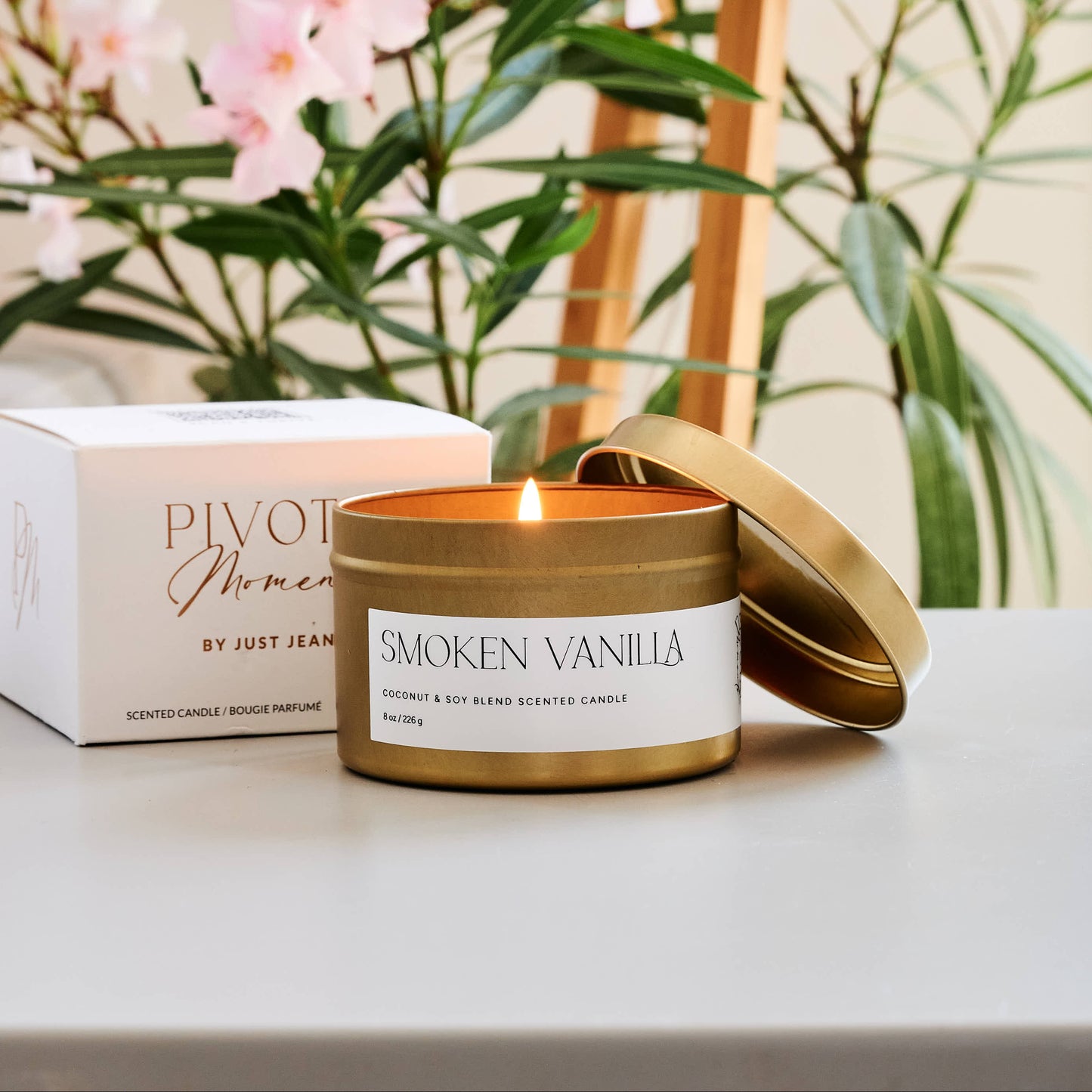 Smoked Vanilla candle with a decorative box and flowers in the background