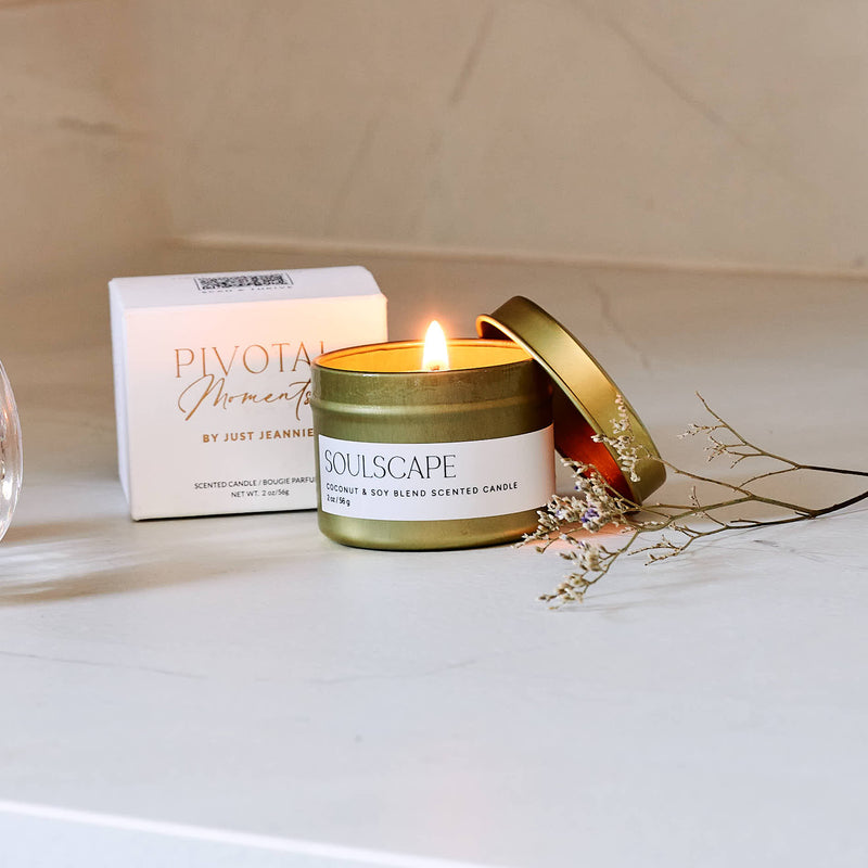 Scented candle with a lit wick on a surface, with 'Pivot' and 'Soulscape' products in the background.