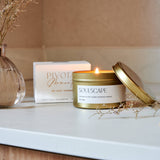 Scented candle labeled 'Soulscapes' on a surface with decorative elements.