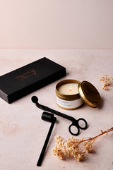 Candle with decorative packaging and accessories on a light surface