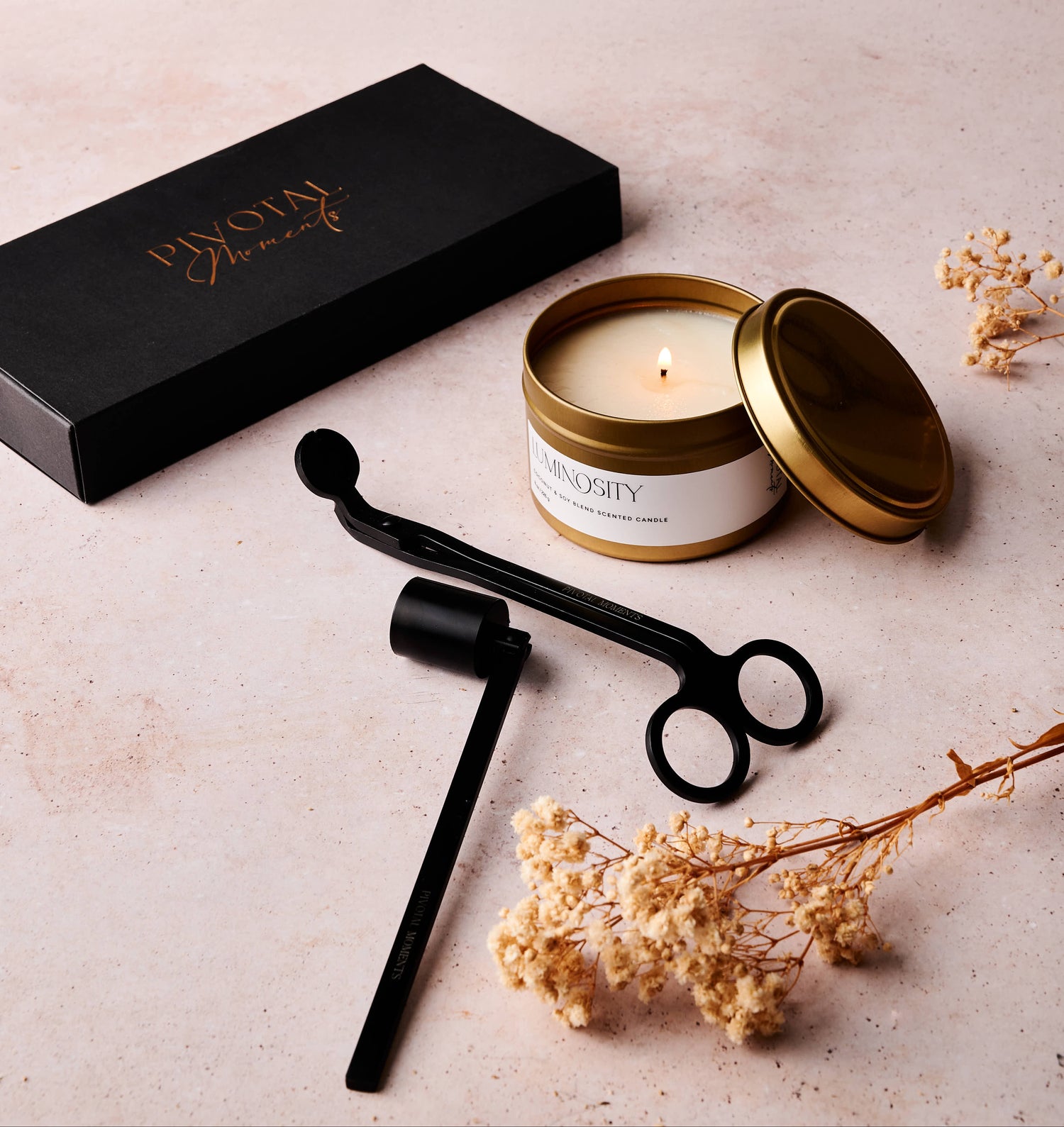 Candle with decorative packaging and accessories on a light surface